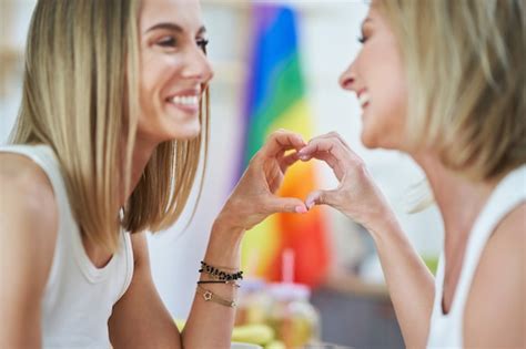 Lgbtのレズビアンのカップルは、キッチンの幸福の概念の瞬間を愛します プレミアム写真