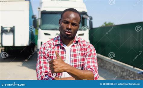 Confident African American Truck Driver Posing With Trucks Stock