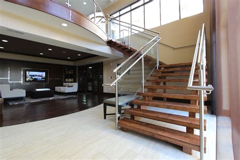 Talbot referenced the warm wood tones of the existing staircase with an orange sofa. Custom Stair Design: 4 Popular Staircase Styles