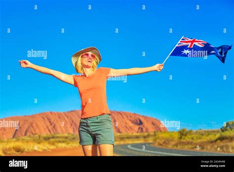 happy lifestyle woman with australian flag in australian outback red centre tourism in northern