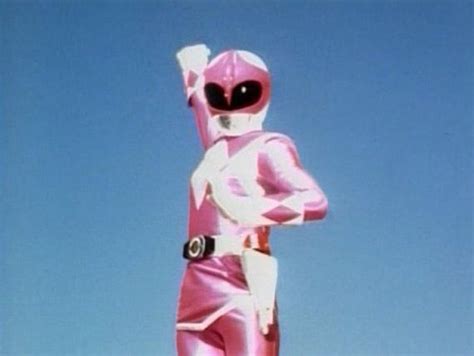 a pink power ranger standing in front of a blue sky