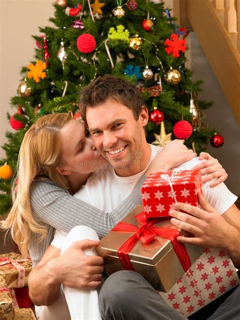 Young Couple With Ts In Front Of Christmas Tree Stock Photo Image