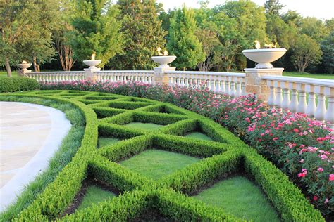 Classic Boxwood Hedges Framed By Cast Stone Ballustrade And Fire Bowls