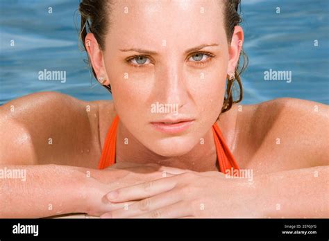 Portrait Of A Young Woman Leaning At The Edge Of A Swimming Pool Stock