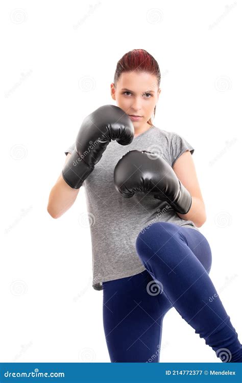 Young Serious Girl With Boxing Gloves Lifting Her Knee Stock Image