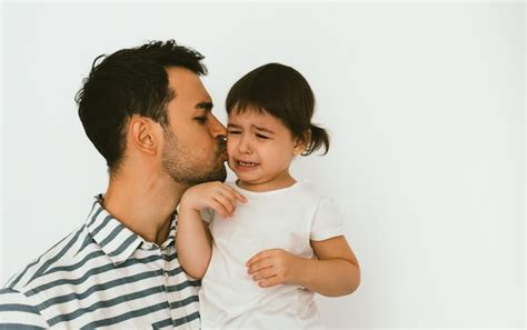 Guapo Padre Sosteniendo Y Besando A Su Hija Llorando Joven Papá