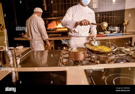Chef Adding Sauce To Vegetables In Cooking Pan Stock Photo Alamy