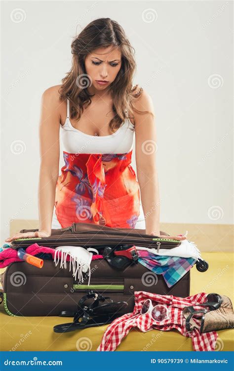 woman struggles to close a full suitcase stock image image of problem stress 90579739