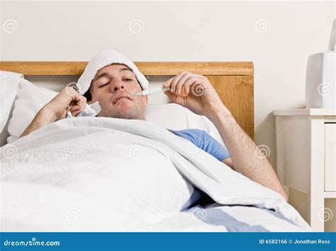 Man With Fever Laying In Bed Taking Temperature Stock Photo Image Of
