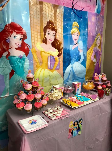 A Table Topped With Cupcakes And Cakes Covered In Frosting