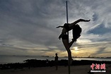 Eye-catching! Girls in leaf bikinis perform pole dance on the beach (3 ...