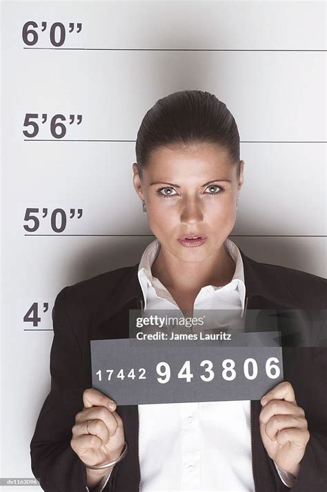 Portrait Of A Businesswoman In A Police Line Up Holding A Identity