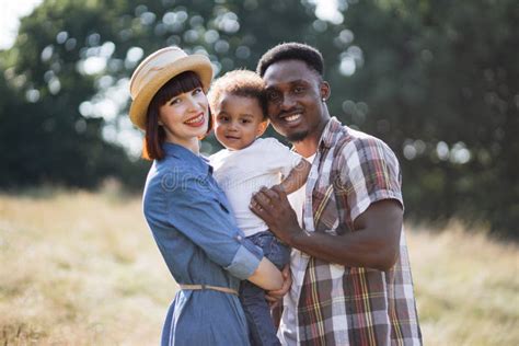 Padres Multiculturales Alegres Abrazando A Un Hijo Pequeño Al Aire