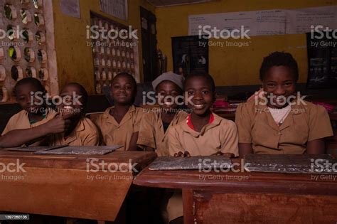 Group Of Pupils Sitting At School Desks With Their Blackboards Happy
