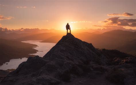 Man Standing On Tip Of Mountain During Golden Hour Hd Wallpaper