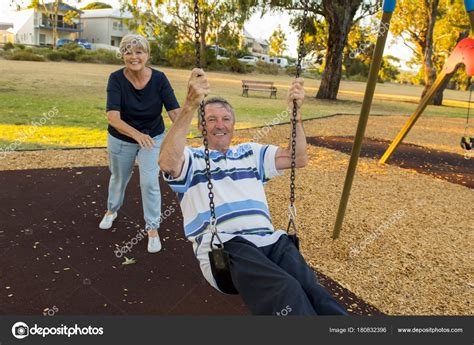Heureux couple américain âgé autour de 70 ans jouissant à swing park