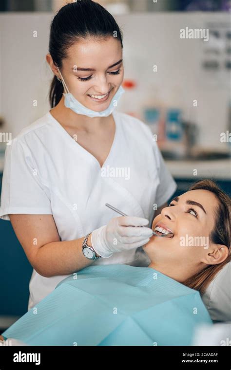 Friendly Dentist Woman Treating Beautiful Patient In Dental Office
