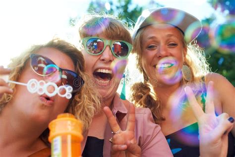 Carefree Fun A Group Of Happy Young Women Having Fun Blowing Bubbles Stock Image Image Of
