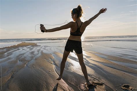 Beautiful Girl Dancing On Beach Listening To Music On Headphones By Stocksy Contributor