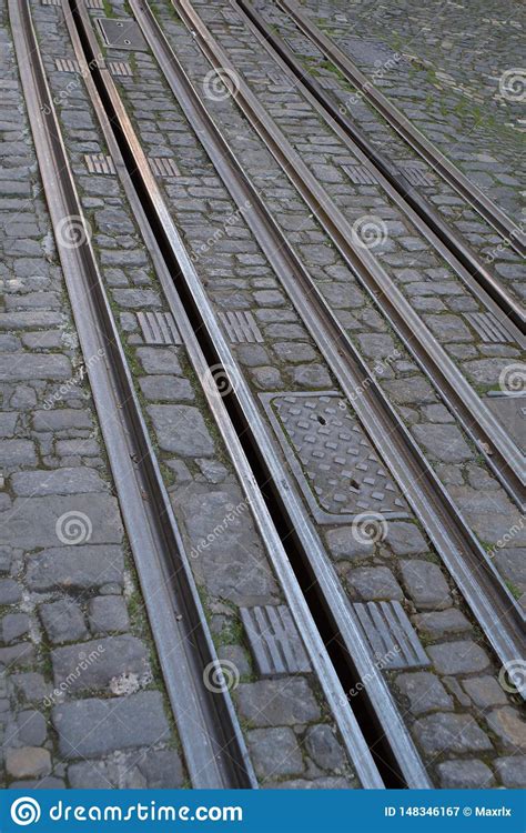 Closeup View Of Tram Tracks Surrounded By Cobblestones In Lisbon Stock