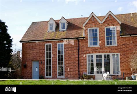 Traditional Brick Country House With Gable Roof And Tall Windows Stock