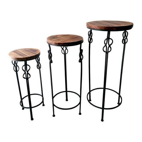 Keep the essentials close with a modern nightstand beside the bed. Small Round Wood & Steel Knot Accent Table - At Home