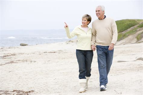 Senior Couple Walking Along Beachhtphq0rs Graphic Stock Elderconsult