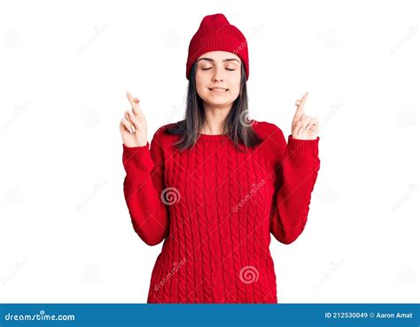 Young Beautiful Girl Wearing Sweater And Wool Cap Gesturing Finger