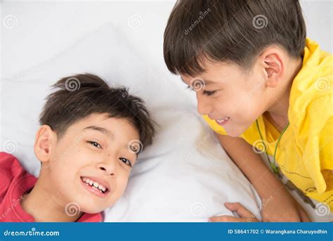 Little Sibling Boy Lay On The Pillow On The Floor Together Stock Photo