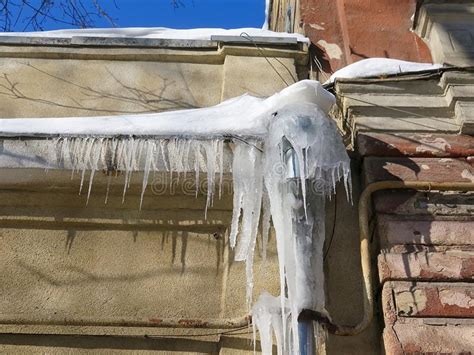 Dangerous Icicles In Winter On The Roof Of The House Stock Photo