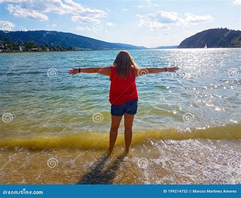 Woman On Her Back Facing The Sea Making A Gesture Of Freedom Stock