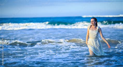 Girl In Wet White Dress Goes In Water At Beach Vacation In Tropical