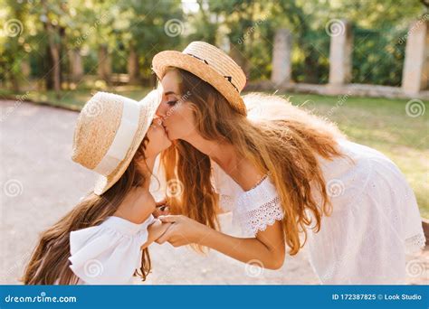 Attractive Stylish Woman Bent Over To The Daughter To Kiss Her Cute