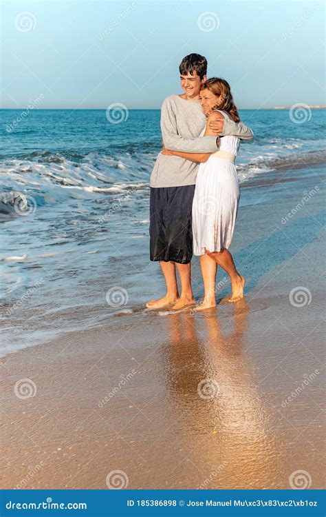 Madre E Hijo Adolescente Abrazándose En La Playa Foto De Archivo