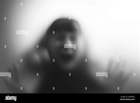 Scared, screaming girl behind the matte glass. Halloween festival