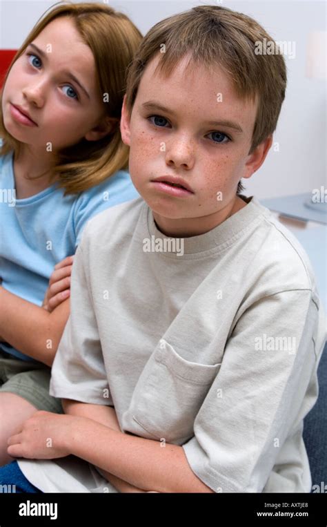 Portrait Of Two Young Kids Crossing Their Arms And Being Bored Stock