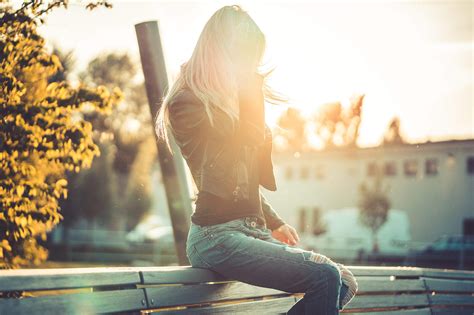 Blonde Woman Sitting Alone on a Bench Against Sunset Free Stock Photo ...
