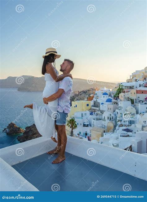 Couple Hugging And Kissing On A Romantic Vacation In Santorini Greece