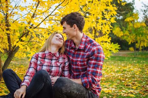 Happy Young Couple Having Fun And Smiling In Autumn Park Outdoors Dr