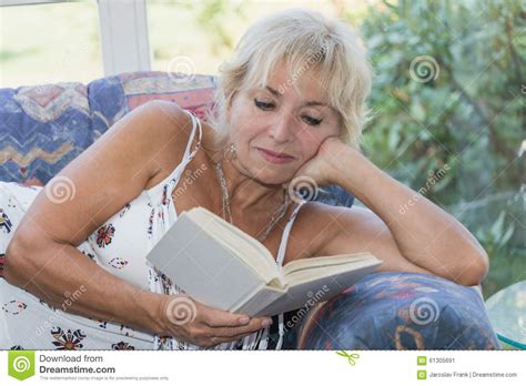 Mature Blond Woman Is Reading Book On The Couch Stock Image Image Of Healthy Attractive 61305691