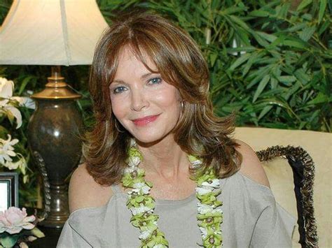 a woman sitting on a couch wearing a green and white flowered lei around her neck