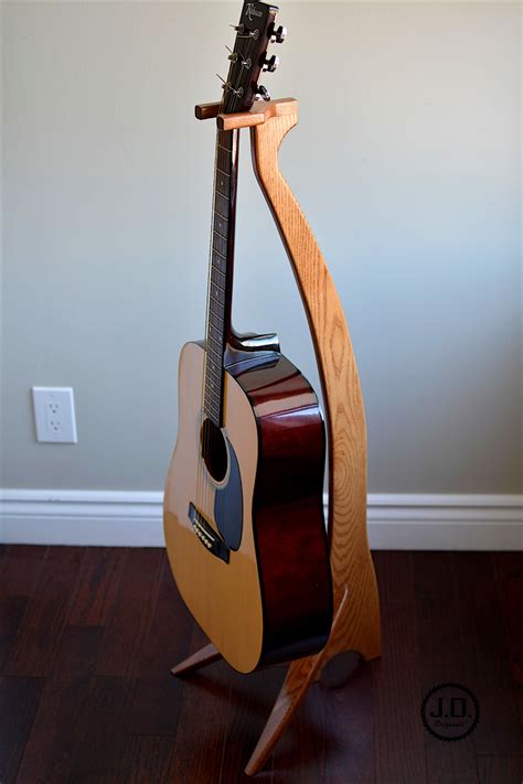 A Guitar Stand Made Out Of Wood With A Guitar Hanging From Its Back