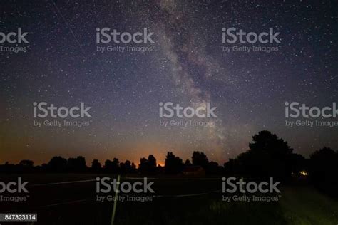 Colorful Milky Way Galaxy Seen In Night Sky Over Trees Stock Photo