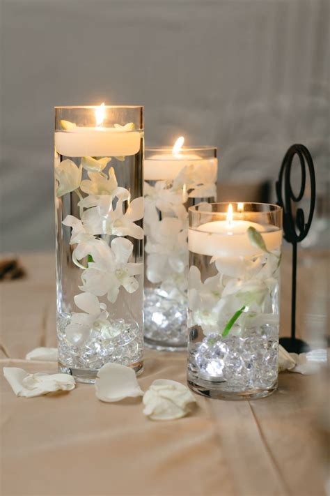 Two Vases With Flowers And Candles On A Table