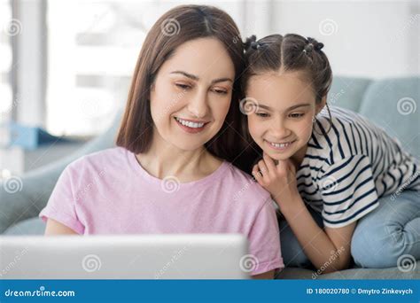 Madre Feliz Y Hermosa Con Hija Mirando La Laptop Foto De Archivo