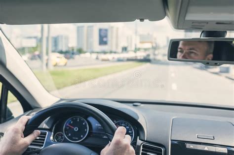 Selective Focus Of Man Hands On Steering Wheel Driving A Car On The