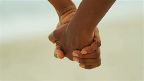Close Up Of African American Female Hands Holding On Beach Stock