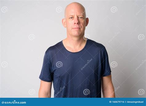 Portrait Of Mature Handsome Bald Man Looking At Camera Stock Photo