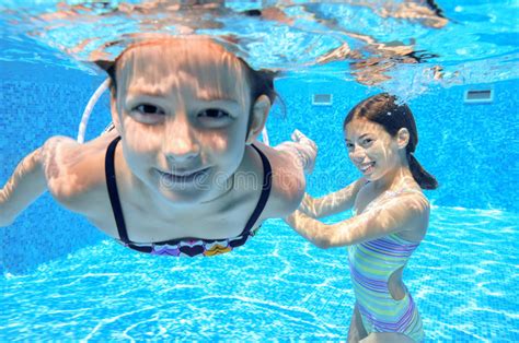 Happy Children Swim In Pool Underwater Girls Swimming Stock Image