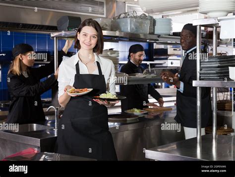 Waitress Holding Meals In Restaurant Kitchen Stock Photo Alamy